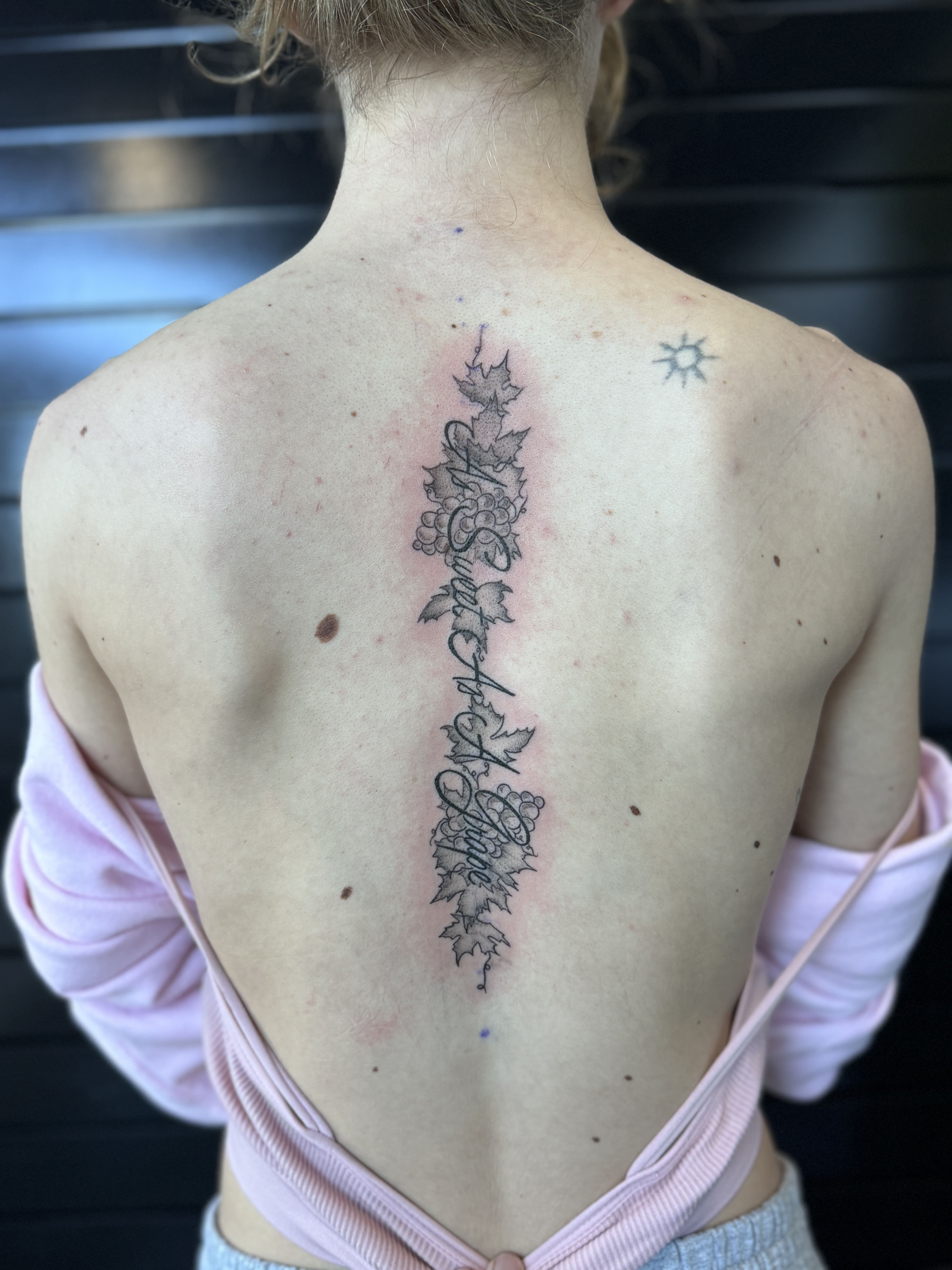 Script and leaves on Spine Tattoo