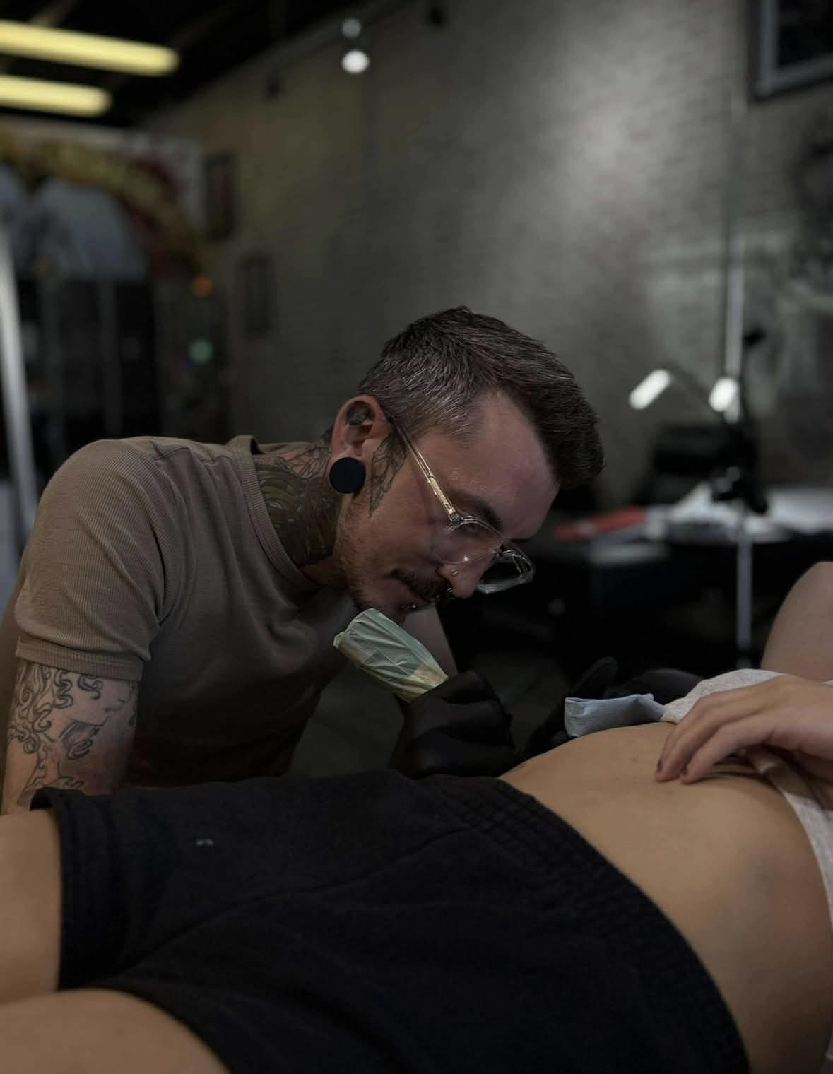 Artist AJ at work in his private, inclusive tattoo studio in Edmonton, showcasing a professional and skin-informed approach to custom tattooing.