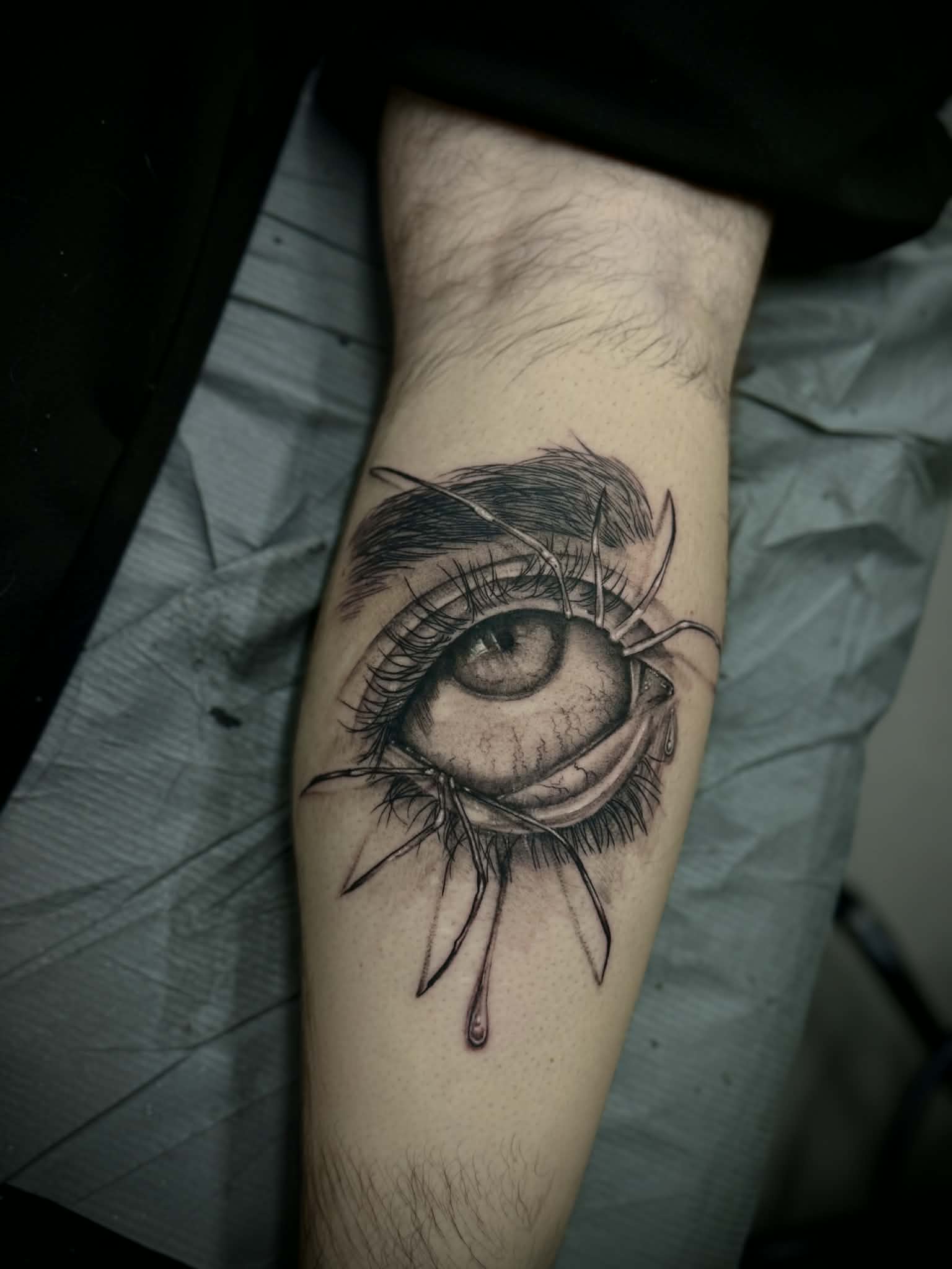 edmonton-surrealist-eyDetailed black and grey realism tattoo of a human eye with spider legs, showcasing expert fine-line work and shading by AJ at Poking Hazard’s private studio in Edmonton, AB.e-tattoo-black-grey-realism-poking-hazard